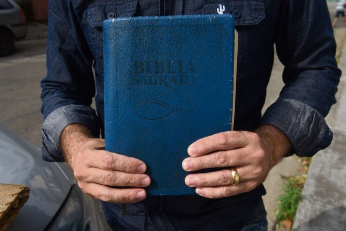 Corretor de imóveis mostra uma das bíblias que ofereceu aos bandidos
