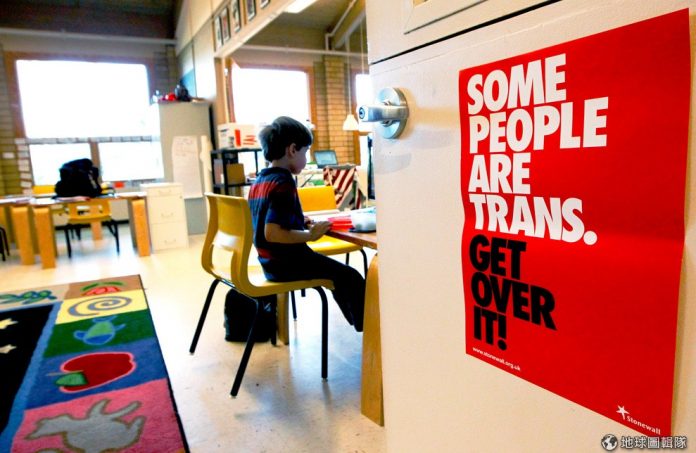 Uma placa do lado de fora de uma sala de aula sobre transgênero