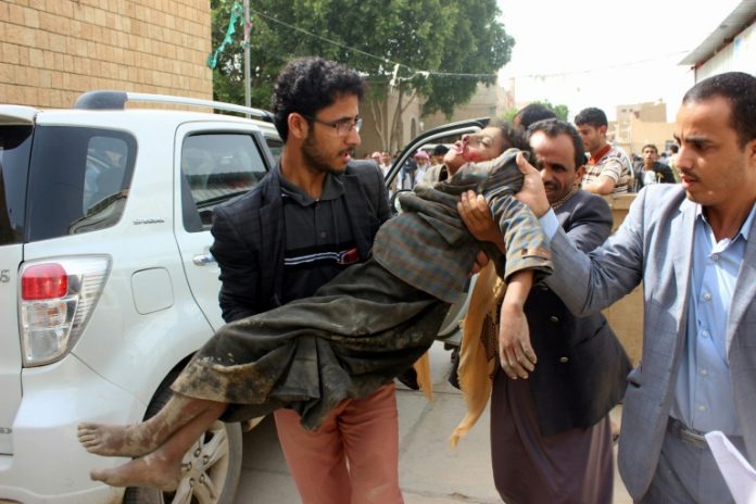 Criança é levada para o hospital após ficar ferida no ataque aéreo no Iêmen