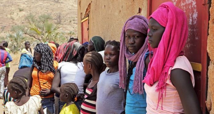 Cristãos reunidos após o culto em igreja do Sudão