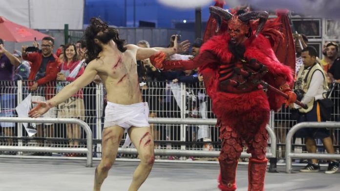 Atores interpretam a luta entre Jesus e o diabo no desfile da escola de samba Gaviões da Fiel, em 2019