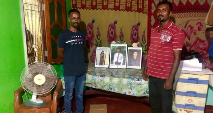 Os cristãos Verl e Nithan mostram fotos da irmã, cunhado e único filho de Verl, mortos no ataque na Páscoa, em Sri Lanka