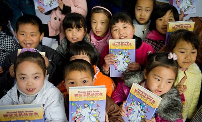 Crianças chinesas com bíblias infantis (Imagem: American Bible Society)