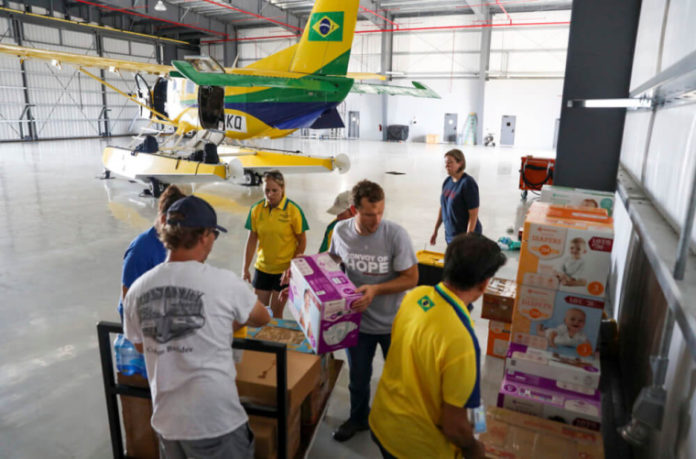 Membros da equipe de serviços internacionais de desastres da Convoy of Hope, juntamente com voluntários, desembalam suprimentos de ajuda humanitária de um avião fretado depois de chegar a Nassau, Bahamas, 7 de setembro de 2019