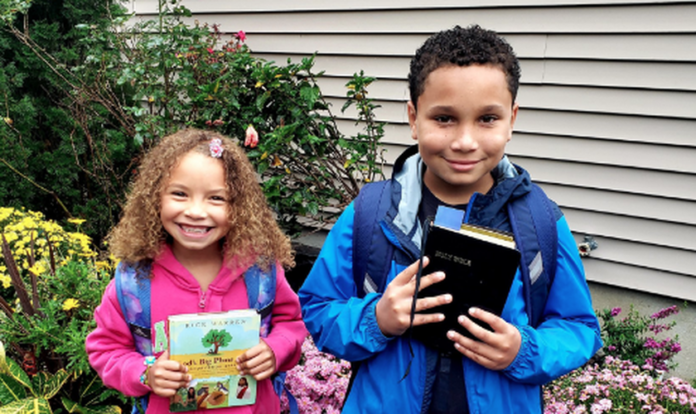 Alunos do condado de Suffolk, em Nova York, fotografam suas Bíblias antes de levá-las para a escola. (Foto: CBN News)