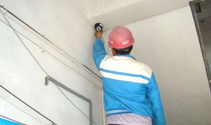 Funcionário do governo instalando uma câmera de vigilância. (Foto: Reprodução/Bitter Winter)