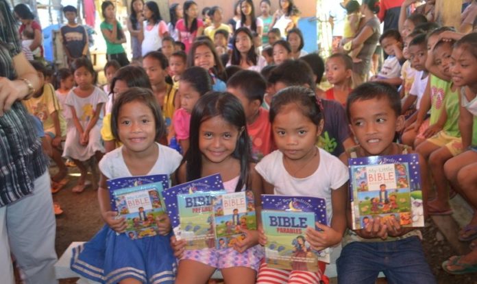 Crianças filipinas com materiais de estudos bíblicos. (Foto: Reprodução/Philippine Bible Society)