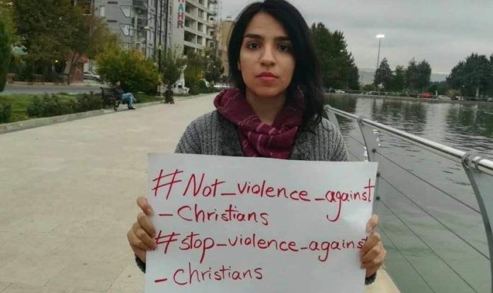 A ativista cristã Mary Fatemeh Mohammadi com placa contra perseguição aos cristãos. (Foto: Reprodução/Twitter)