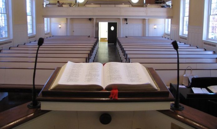 Bíblia aberta em púlpito de uma igreja vazia