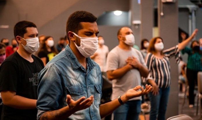 Fiéis participam de culto com máscara em meio a pandemia do coronavírus