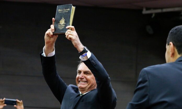 Presidente Jair Bolsonaro segurando uma Bíblia