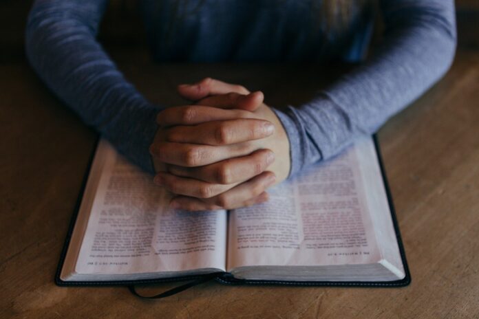 Mãos postas sobre a Bíblia (Imagem de Free-Photos por Pixabay)