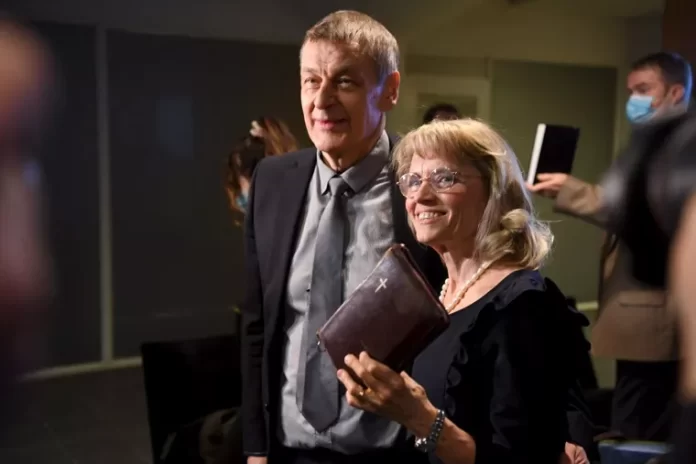 A deputada cristã Paivi Rasanen, segura uma Bíblia ao chegar com seu marido Niilo Rasanen para o julgamento no Tribunal Distrital de Helsinque, na Finlândia