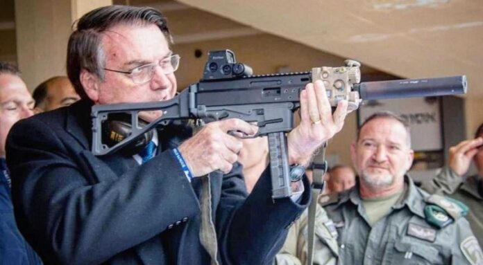 Bolsonaro com uma metralhadora nas mãos