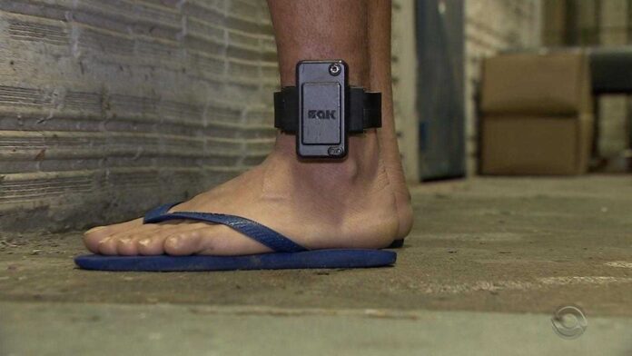 Pessoa com tornozeleira eletrônica na perna