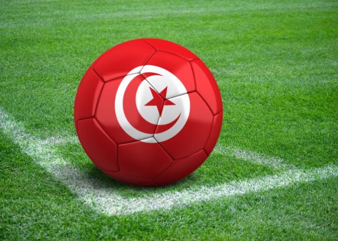 Bola com a bandeira da Tunísia na marca de escanteio de um campo de futebol (Foto Montagem/FolhaGospel)