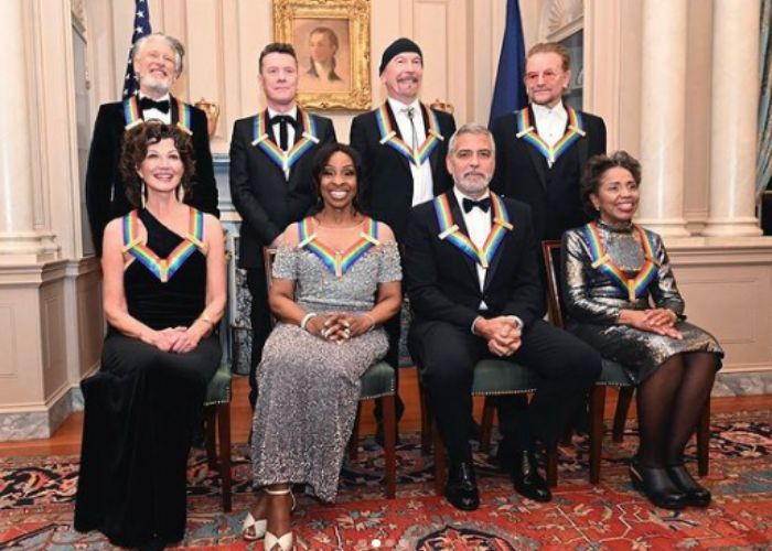 Amy Grant e os demais homenageados do Prêmio Kennedy Center Honors 2022 (da esq. para dir. sentados: Amy Grant, Gladys Knight, George Clooney e Tania León. O integrantes dda banda U2 estão de pé)