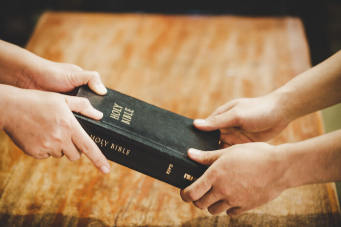 Bíblia sendo doada durante evangelização (Foto representativa)