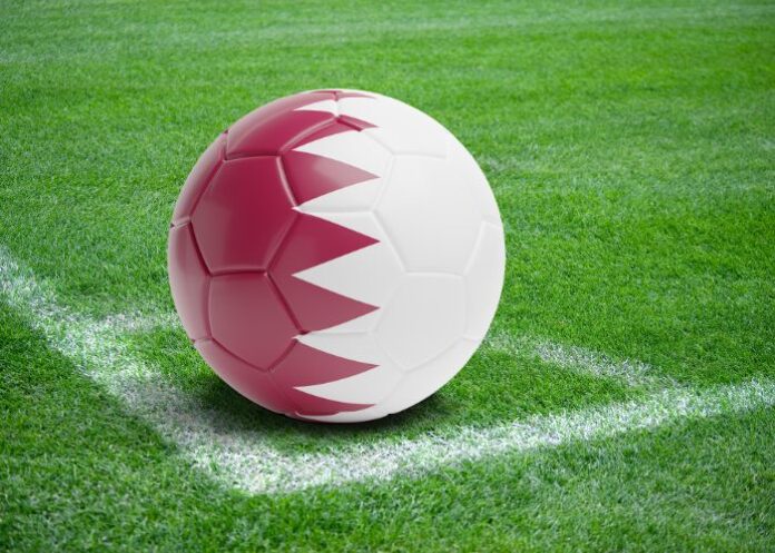 Bola com a bandeira do Catar na marca de escanteio de um campo de futebol (Foto: Montagem/FolhaGospel)