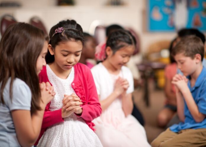 Crianças orando (Foto Canva Pro)